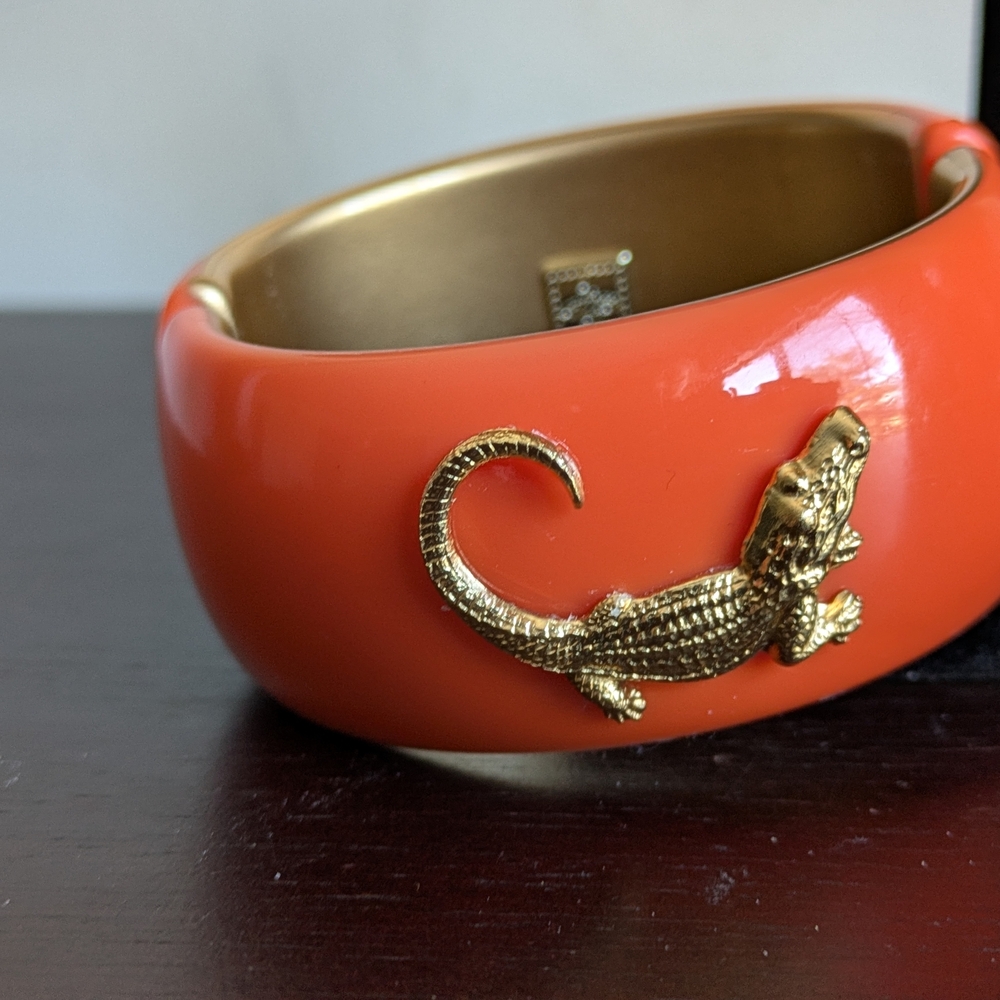 lisi lerch orange acrylic with a solid brass alligator motif with tarnish resist